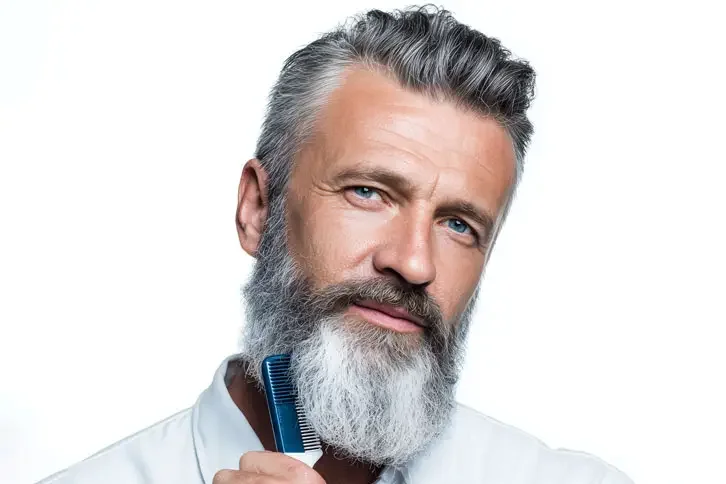 Homem penteando a barba grisalha com pente
