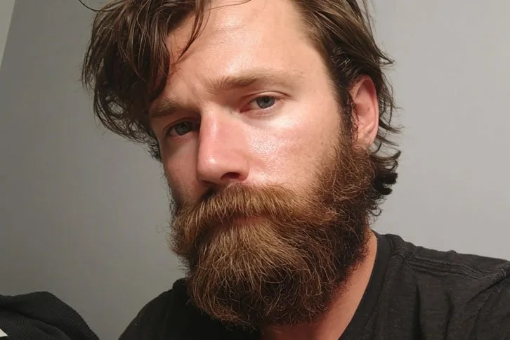 Homem com barba longa castanho-avermelhada, bem hidratada