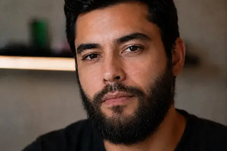 Homem com a barba cheia crescida antes de desenhar o cavanhaque